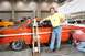 1965 Ford Falcon - A man poses with a trophy next to a vintage orange Ford Falcon at a car show.