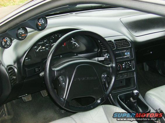 Interior of a 1995 Ford Probe, showing dashboard, steering wheel with 'PROBE' logo, gauges, and gear shifter