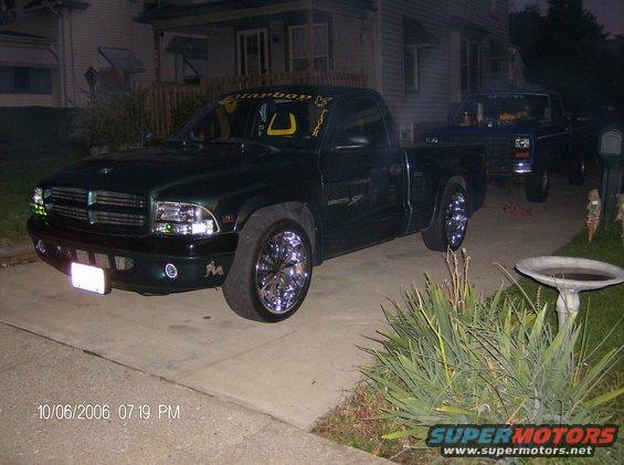 Dark green pickup truck with chrome rims parked in a driveway