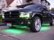 1970 Ford Ranchero - A dark green pickup truck with custom green underglow lighting and chrome wheels is parked on a driveway.