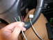 1996 Ford Probe - A hand holds several wires near the steering wheel of a vehicle, with the SRS airbag text visible.
