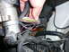 1996 Ford Probe - A close-up view of a vehicle's electrical wiring harness and connectors, with a hand disconnecting a plug.