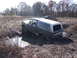 1979 Ford Bronco - A Ford Bronco is stuck in the mud off-road, with another vehicle visible in the distance.