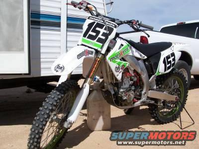 White motocross dirt bike with green accents and number 153 on front and side