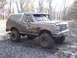 1979 Ford Bronco - This heavily mud-splattered 1987 Ford Bronco is shown in a wooded area, likely after off-road use.