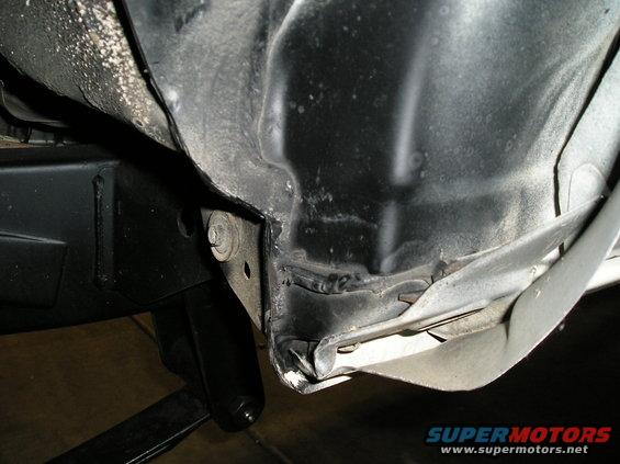 Close-up of damaged vehicle frame and fender attachment point