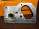 1996 Ford Bronco - A metal bracket with various holes and brass fittings is shown against a blurred orange background.