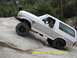 1996 Ford Bronco - White Ford Bronco navigating a challenging rocky terrain.