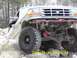 1996 Ford Bronco - A 1996 Ford Bronco navigates a rocky terrain, its lifted suspension and off-road tires.