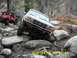 1996 Ford Bronco - White Ford Bronco and red Jeep tackling a challenging rocky off-road course.