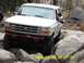 1996 Ford Bronco - White 1996 Ford Bronco tackles a challenging off-road course with large boulders.