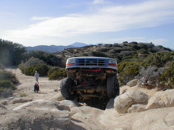 1996 Ford Bronco climbing over rocks on an off-road trail