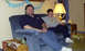 1999 Ford Crown Victoria - A man and a boy relax on a couch, with a birthday banner visible in the background.