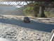 1993 Ford Bronco - An SUV kicks up dust as it drives down a rocky dirt road beneath a large bridge.