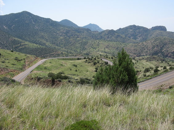 Winding mountain road with a distant motorcycle rider on a switchback