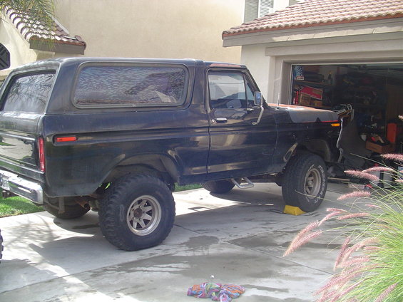 Side view of a black 1978 Ford Bronco parked in a driveway