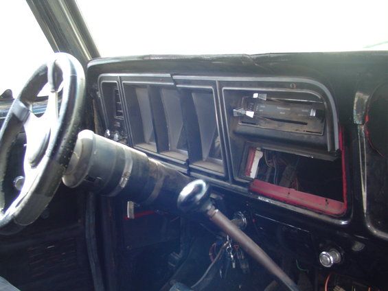 Interior shot of a car dashboard with a steering wheel, vents, and radio area