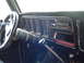 1978 Ford Bronco - The dashboard of an older vehicle shows a steering wheel, air vents, and an open radio slot.