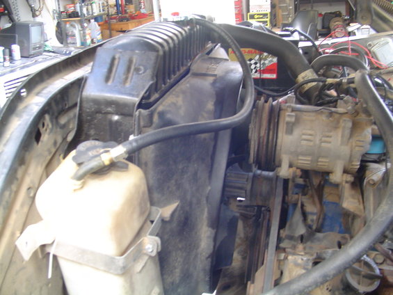 engine bay with radiator, fan, and air conditioning compressor visible