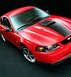 1999 Ford Mustang - Red 1999 Ford Mustang coupe with black racing stripes on hood and front quarter view.