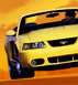 1999 Ford Mustang - Yellow 1999 Ford Mustang convertible shown from the front quarter angle. Website logo visible.