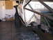 1986 Toyota Hilux - A white pickup truck is modified with a roll cage and large off-road tires, seen from the side in a garage setting.