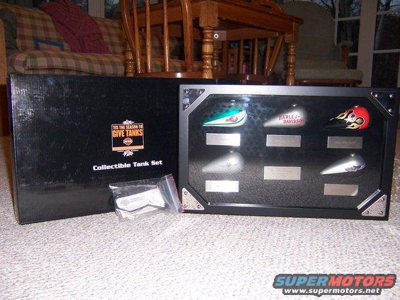 Collectible Harley-Davidson fuel tanks in a display case, with a black box labeled 'Collectible Tank Set'