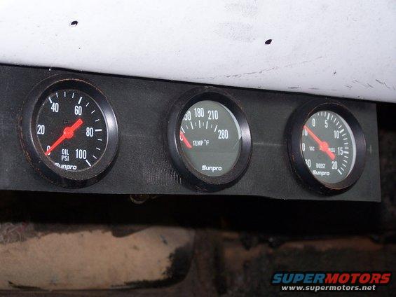 Three Sunpro gauges: oil pressure, temperature, and boost, mounted on a black panel