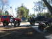 2001 Ford F-250 - Two trucks and a motorcycle are parked outside on a sunny day, with one person working on the red truck.