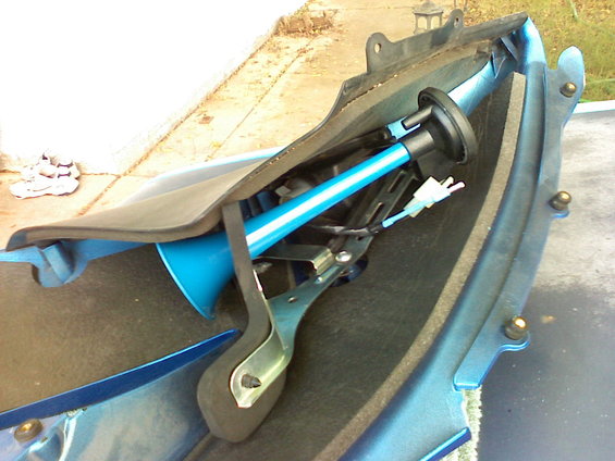 Blue motorcycle fairing section with a blue and white striped air horn and wiring