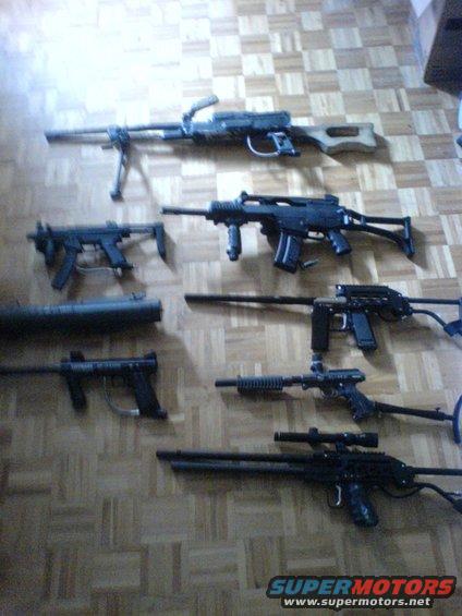 Various firearms laid out on a wooden floor