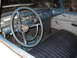 1959 Ford Ranchero - The interior of a 1959 Ford Ranchero shows a blue dashboard, steering wheel, and dark vinyl seat.