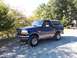 1996 Ford Bronco - This blue Ford Bronco is parked outdoors on a sunny day.