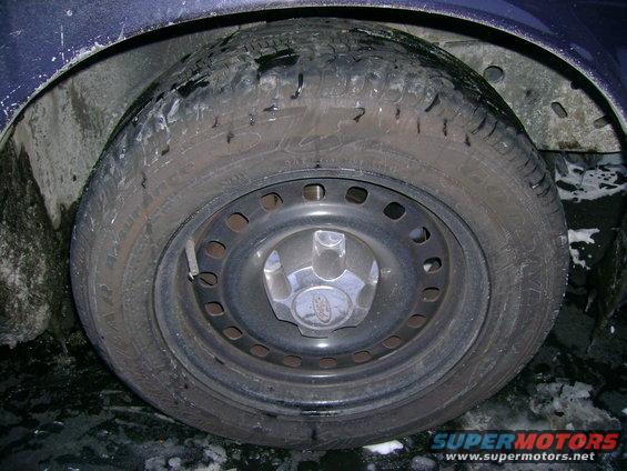 Close-up of a car wheel and tire with a Ford logo on the hubcap