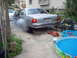 1970 Ford Ranchero - A silver Ford Crown Victoria is performing a burnout in a driveway, with smoke billowing from the rear tire.