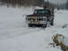 1979 Ford Bronco - A maroon Ford Bronco navigates a snowy terrain, its front bull bar equipped with lights.