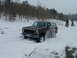 1979 Ford Bronco - A Ford Bronco navigates a snowy, wooded area, with snow spraying from its tires.