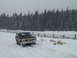 1979 Ford Bronco - A 1978 Ford Bronco navigates a snowy path, bordered by a rustic wooden fence and dense pine forest.