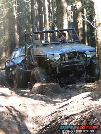 Blue off-road buggy stuck in mud with another vehicle behind it
