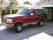 1994 Ford Bronco - This 1994 Ford Bronco is shown in a 3/4 front view, parked in a driveway next to a garage.