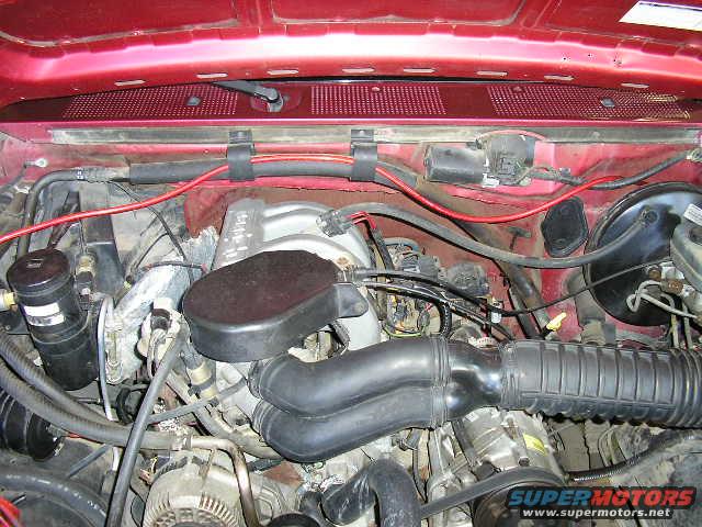 1994 Ford Bronco engine bay with red hood, black air intake, and silver engine components