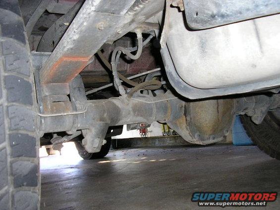 Rear leaf spring and differential housing of a vehicle, showing rust and wear