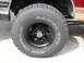1994 Ford Bronco - A close-up view of a vehicle's wheel and tire, showing the tread pattern and sidewall markings.