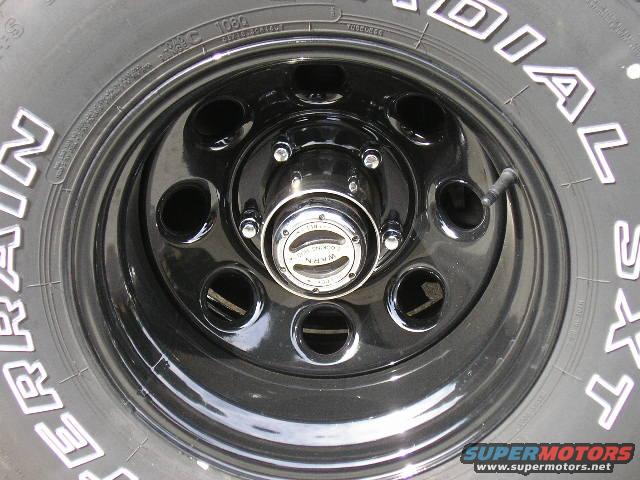 Black steel wheel with a chrome hubcap and tire tread visible