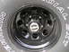 1994 Ford Bronco - Close-up of a black steel wheel with a chrome hubcap and visible tire tread.
