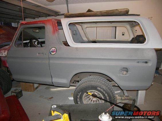 Gray 1978 Ford Bronco in a garage, side view, undergoing bodywork