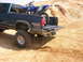 1994 Ford Bronco - A dirt bike is loaded into the bed of a pickup truck, ready for off-road adventures.