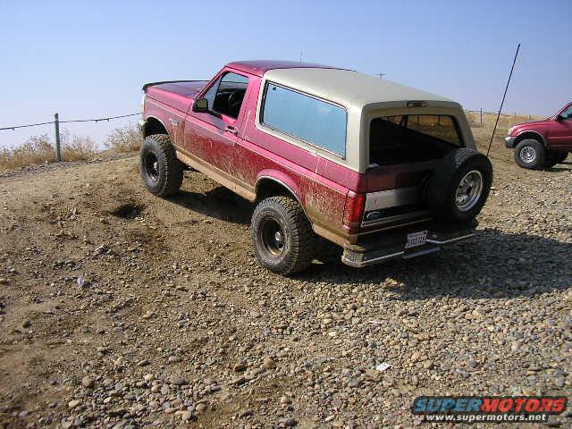 Red and tan 1992 Ford Bronco on a dirt trail