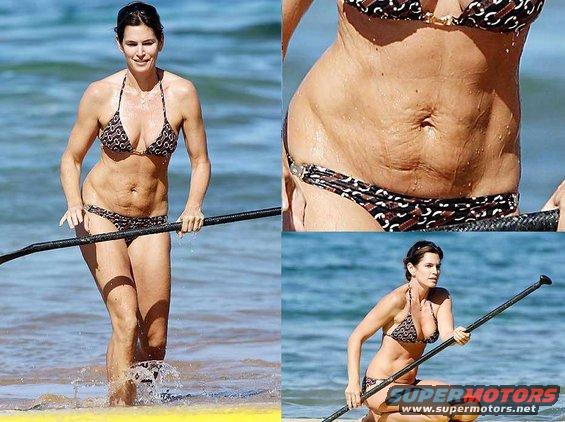 Woman in a patterned bikini on a paddleboard in the ocean, holding a paddle