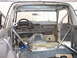 1996 Ford Bronco - The interior of a 1996 Ford Bronco shows a custom roll cage and a stripped-down dashboard.